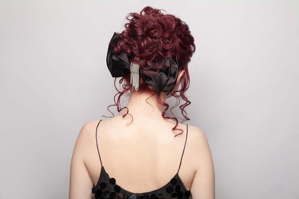 Собранная прически с большой заколкой-бантом