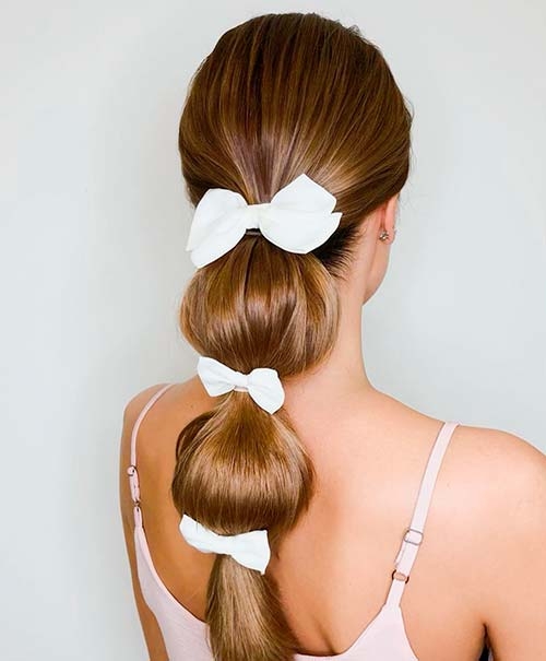 Прически с несколькими белыми заколками-бантами