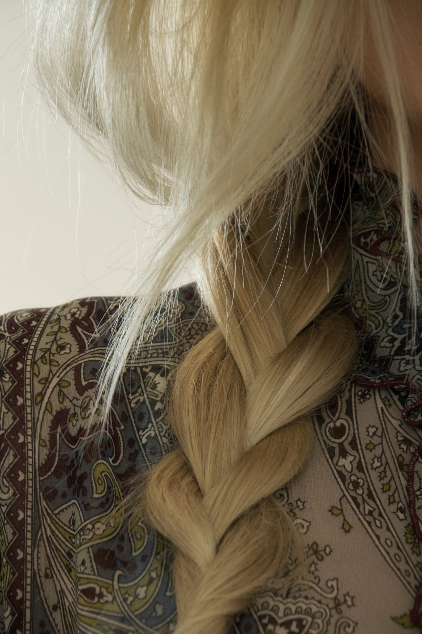 Коса, уложенная на одно плечо, для создания уютного зимнего силуэта 