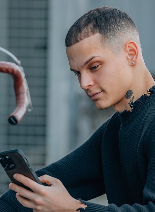 Мужчина с бородой и стрижкой кроп в кожаной куртке и худи