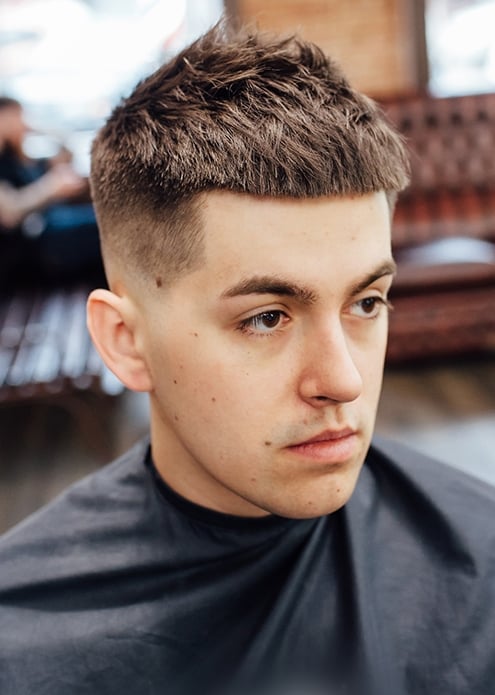 Молодой мужчина с короткой стрижкой и выбритыми висками