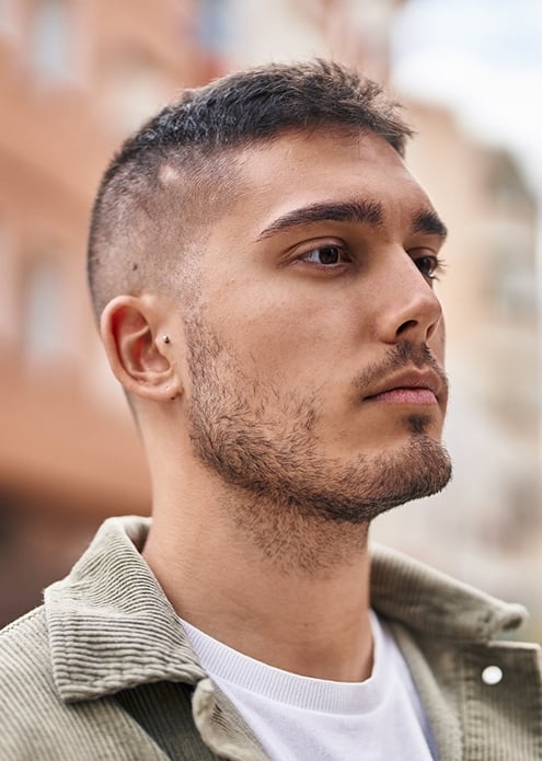 Молодой мужчина с короткой стрижкой и выбритыми висками