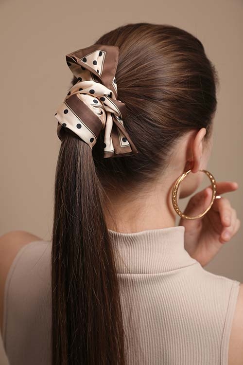 Девушка с гладким хвостом, украшенным стильной лентой с узором